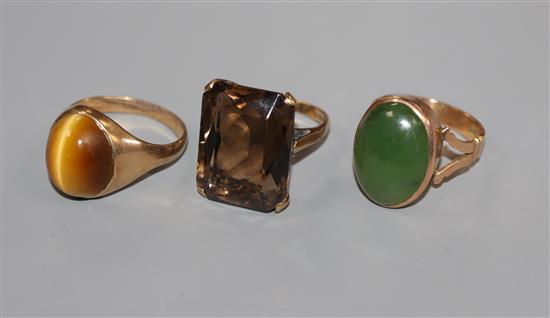 A 9ct gold and quartz dress ring, a similar tigers eye quartz ring and a 9ct and green cabochon ring.